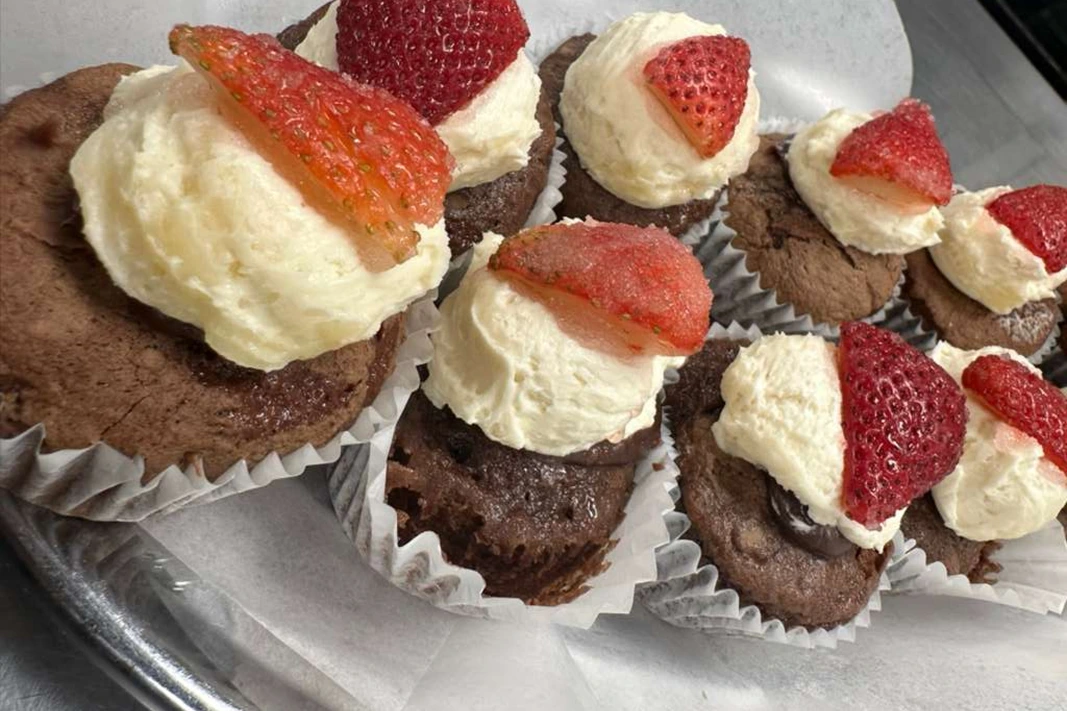A tray of freshly decorated vegan cupcakes made in a camp kitchen